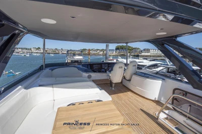 Luxurious 2023 Princess S72 yacht interior with elegant seating and scenic marina view.
