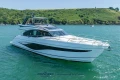 Luxury 2023 Princess S72 yacht cruising on a scenic, sunny waterway.