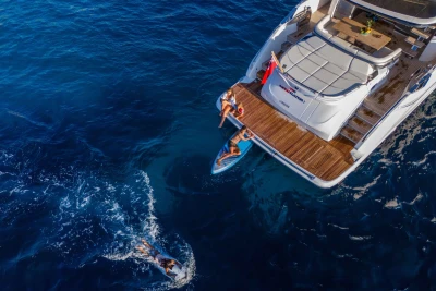 Aerial view of 2023 Princess S72 yacht with people enjoying water activities.