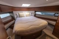Luxurious 2019 Princess F50 yacht bedroom with elegant wood finishes and cozy bedding.