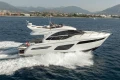 2019 Princess F50 yacht cruising on open water with scenic mountain backdrop.
