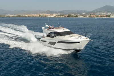 2019 Princess F50 yacht cruising on open water with scenic coastal backdrop.
