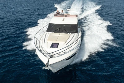 2019 Princess F50 yacht cruising on open blue sea, creating a dynamic wake.