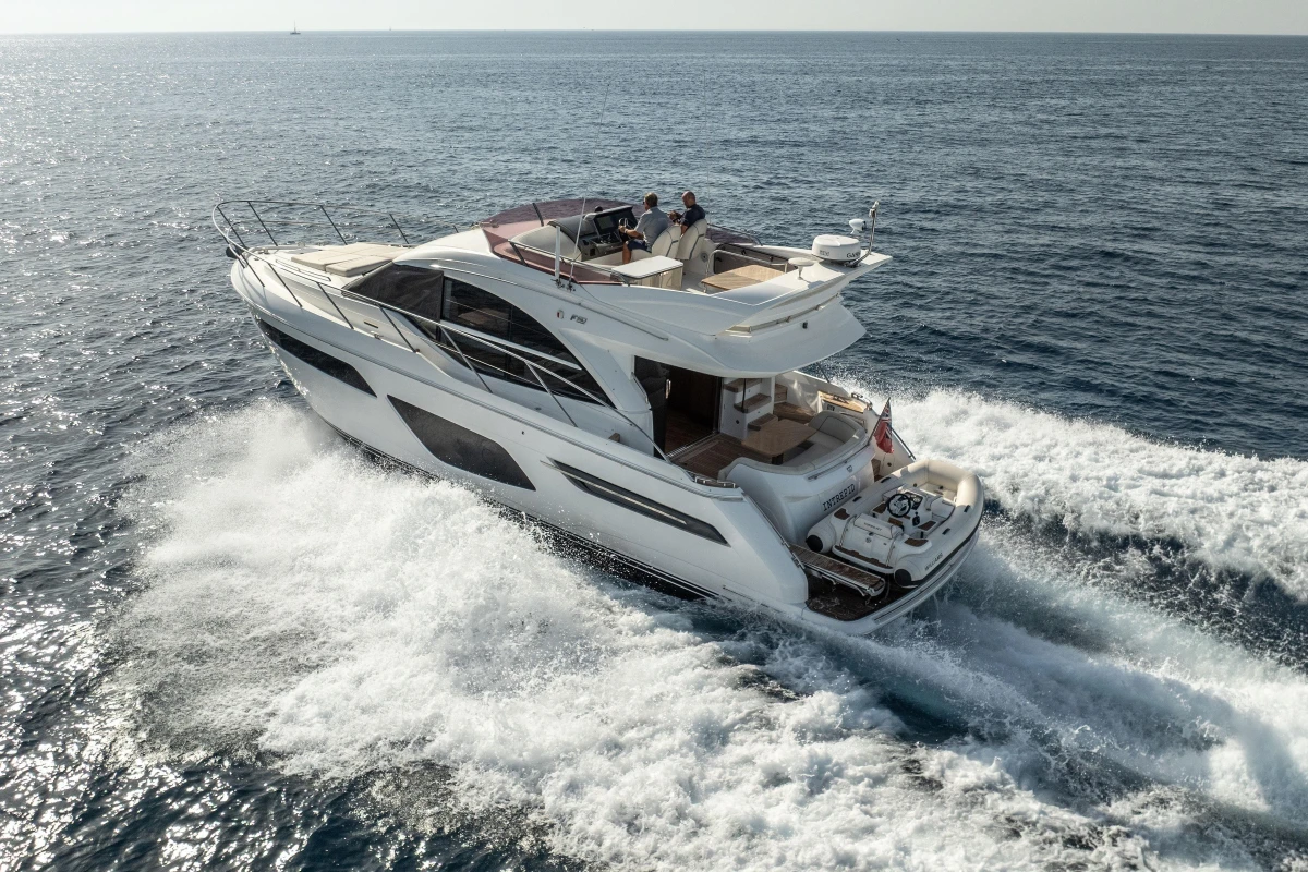 Luxurious 2019 Princess F50 yacht cruising on open sea, creating waves.