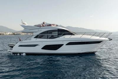 2019 Princess F50 yacht cruising on calm waters with scenic mountain backdrop.