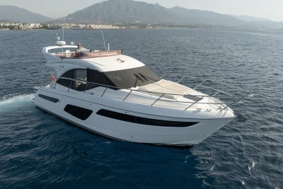 Luxury 2019 Princess F50 yacht cruising on open sea with scenic mountain backdrop.