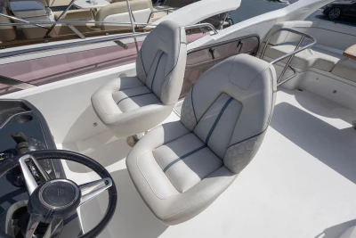 Luxury seating on 2019 Princess F50 yacht with modern steering wheel.