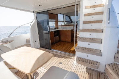 Luxurious 2019 Princess F50 yacht interior with wooden stairs and dining area.