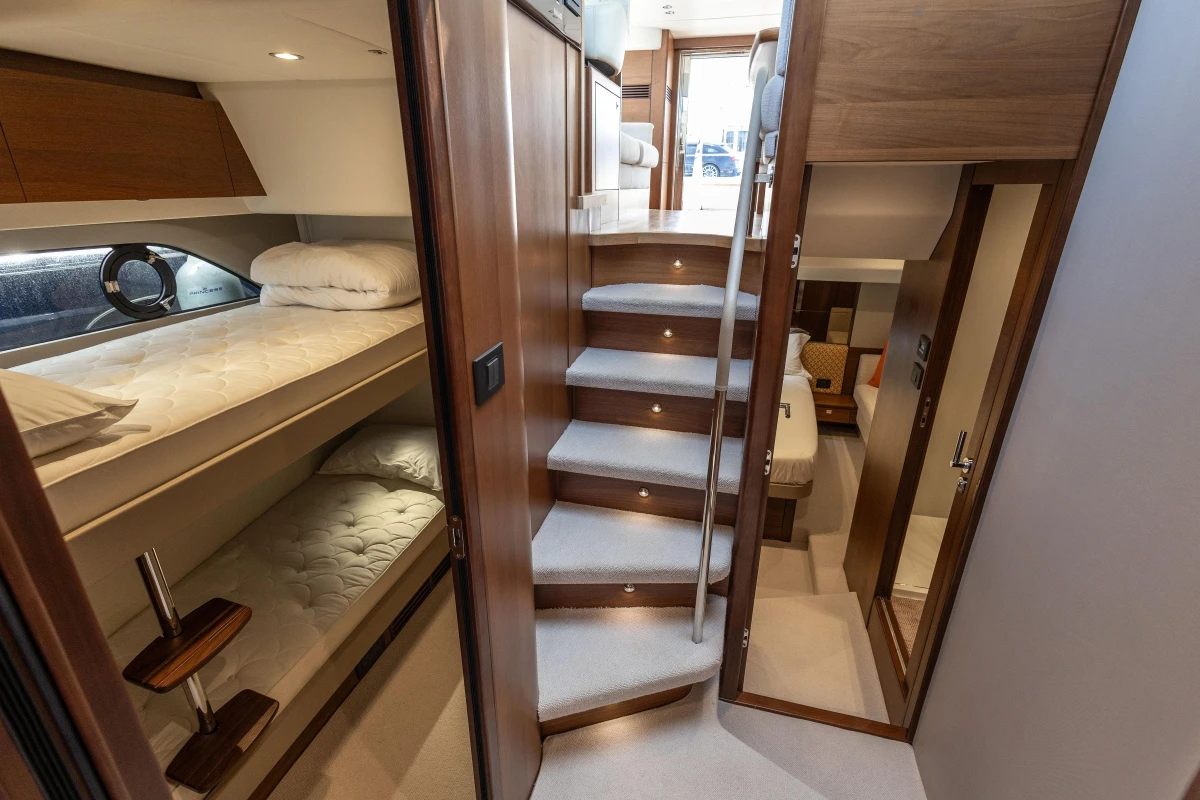 Luxurious interior of 2019 Princess F50 yacht with bunk beds and elegant staircase.