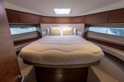 Luxurious cabin interior of 2019 Princess F50 yacht with cozy bed and wooden accents.