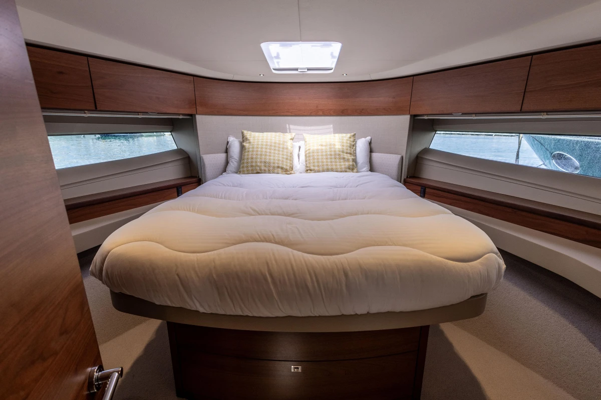 Luxurious cabin interior of 2019 Princess F50 yacht with cozy bed and wooden accents.