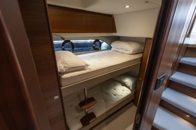 Luxurious 2019 Princess F50 yacht cabin with cozy bunk beds and elegant wood finishes.