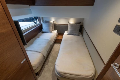 Luxurious twin cabin interior on 2026 Princess F65 yacht, featuring modern design and cozy bedding.