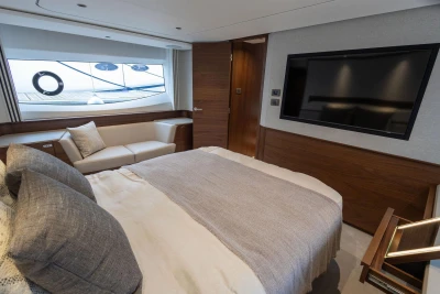 Luxurious bedroom interior of 2026 Princess F65 yacht with modern decor and large window view.