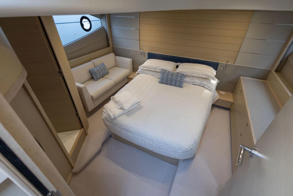 Luxurious 2018 Princess V50 yacht bedroom with elegant decor and cozy seating area.
