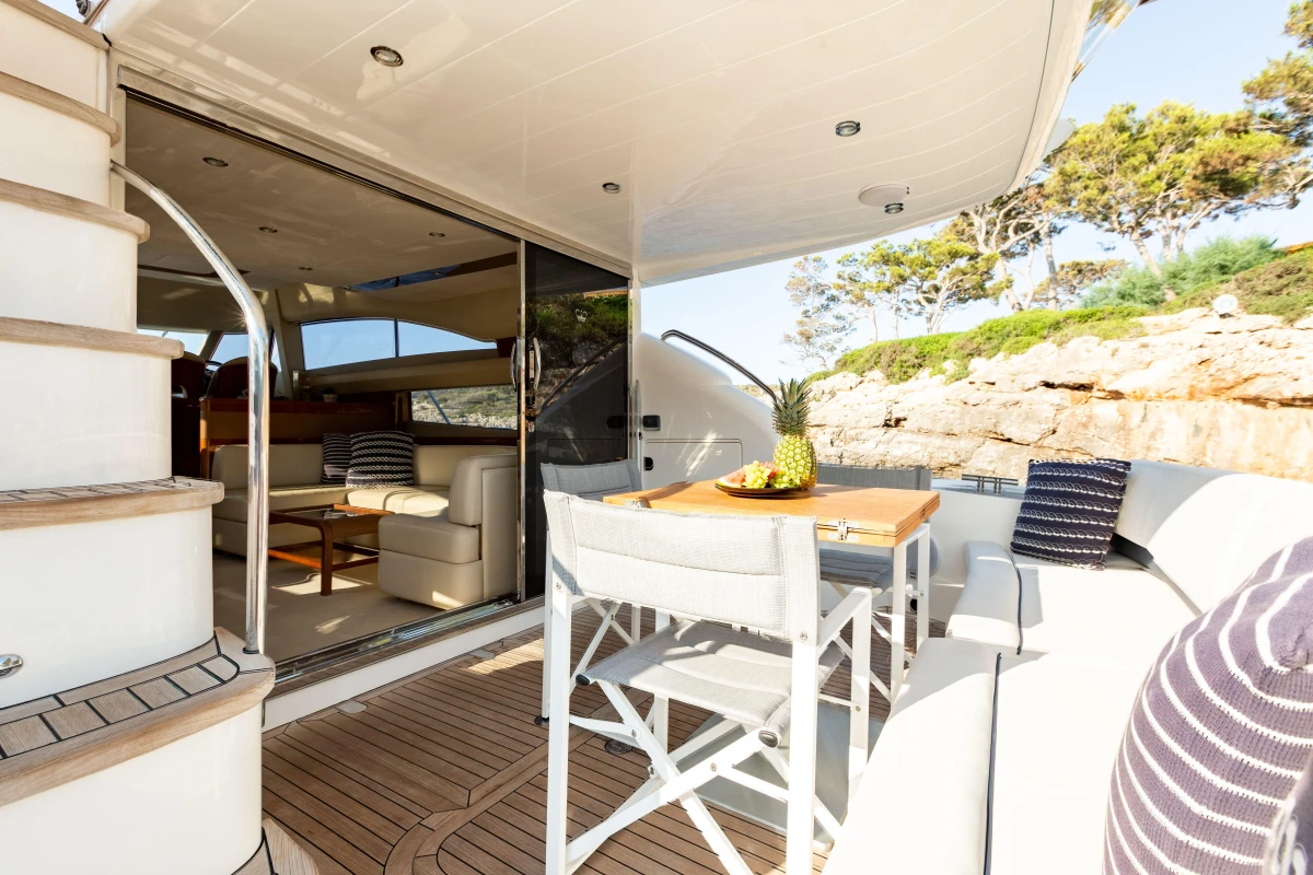 Luxurious 2008 Princess 58 yacht deck with seating, table, and scenic view.