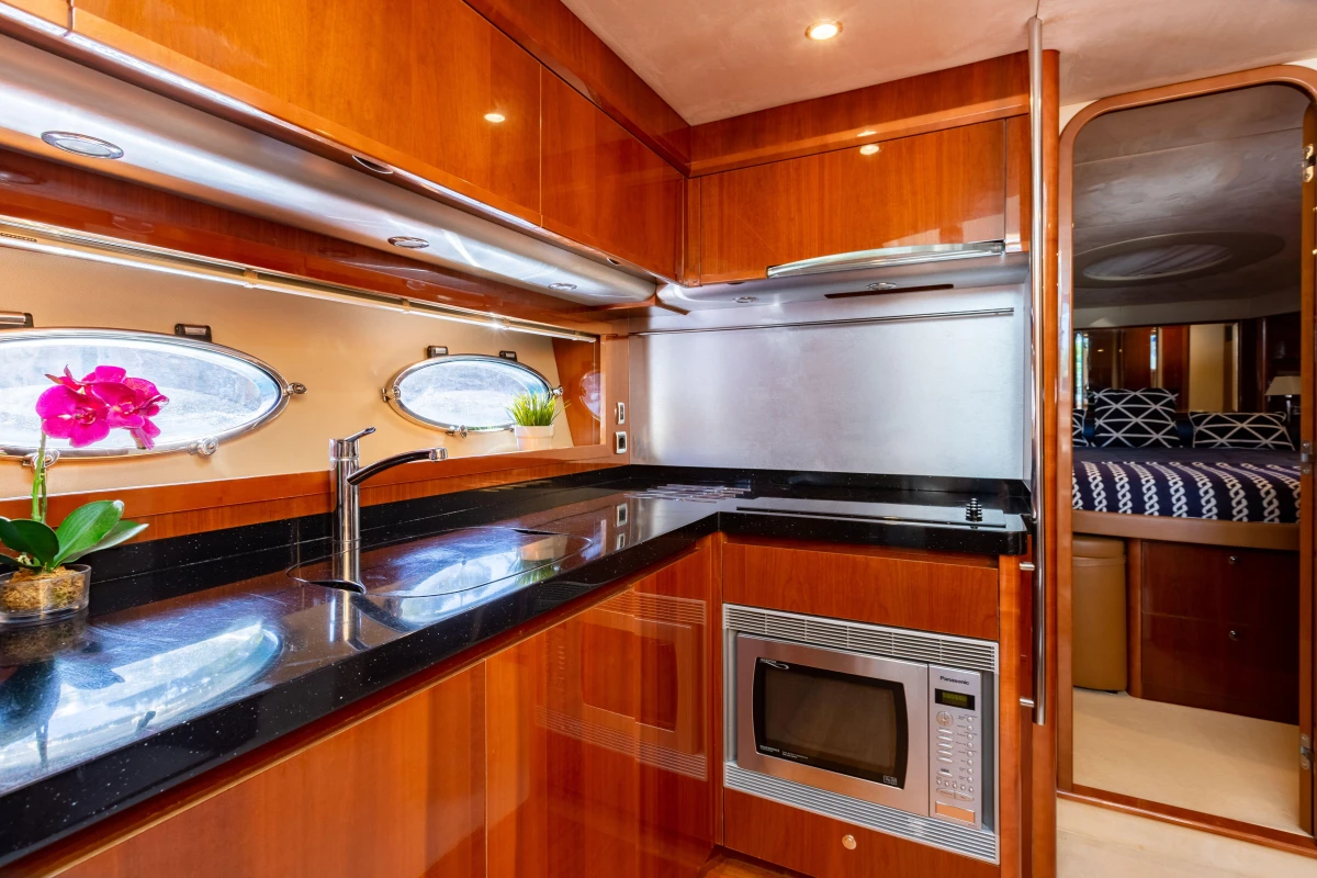 Luxurious 2008 Princess 58 yacht kitchen with sleek wood cabinetry and modern appliances.