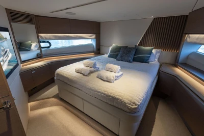 Luxurious bedroom interior of 2021 Princess Y72 yacht with elegant bedding and ambient lighting.