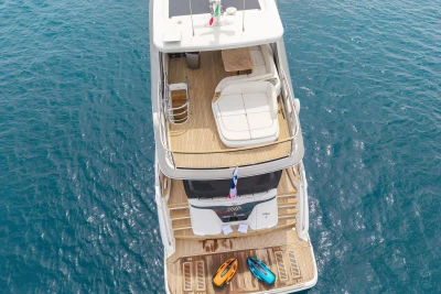 Aerial view of 2021 Princess Y72 yacht with kayaks on deck, floating on blue ocean water.