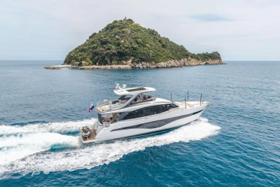 Luxurious 2021 Princess Y72 yacht cruising near a lush island.