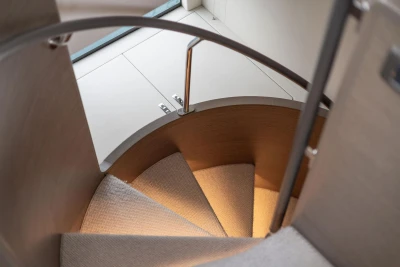 Spiral staircase inside 2021 Princess Y72 yacht, featuring elegant design and soft lighting.