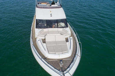Aerial view of a luxury motor yacht on calm water.