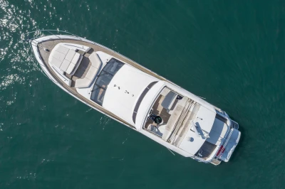Aerial view of a luxury motor yacht on calm water.