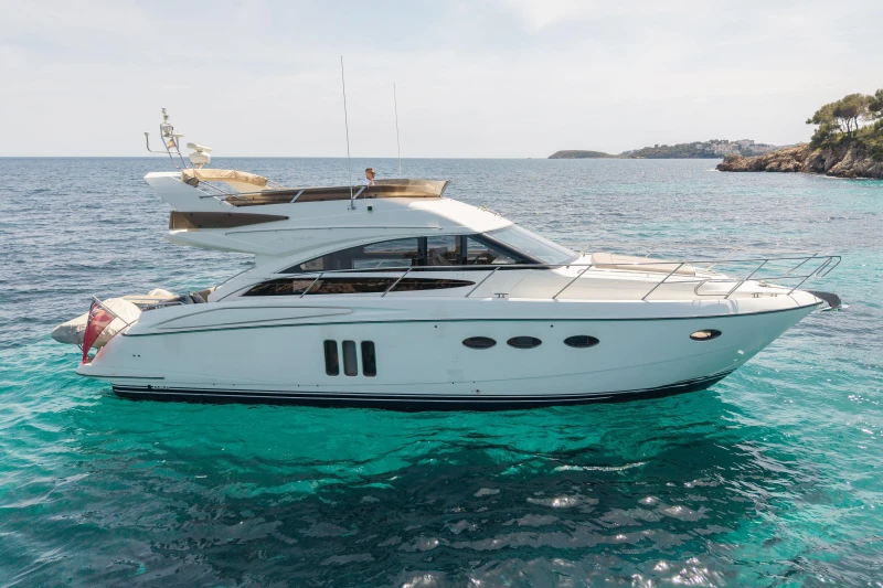 Luxury 2010 Princess 50 yacht cruising on clear turquoise waters.