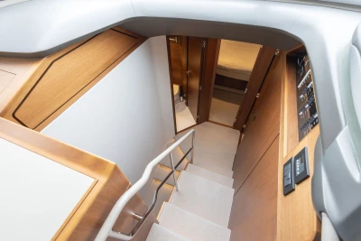 Interior staircase of 2022 Princess F55 yacht, featuring modern wood paneling and sleek design.