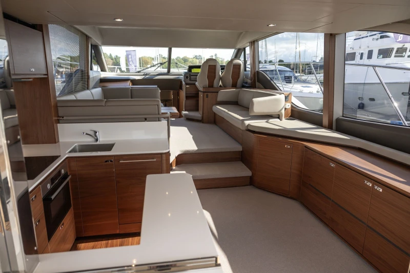 Luxurious interior of 2022 Princess F55 yacht with modern kitchen and seating area.