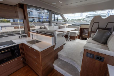 Luxurious interior of 2026 Princess F50 yacht with modern kitchen and seating area.