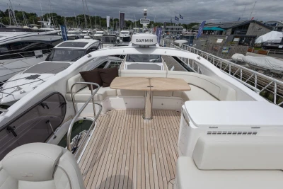 Luxurious 2026 Princess F50 yacht deck with seating and table, docked at marina.