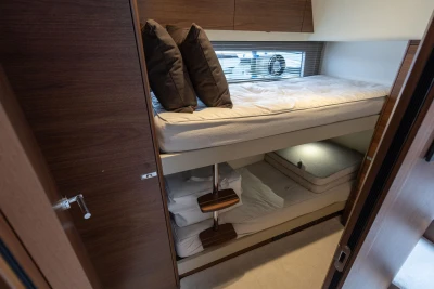 Luxurious 2026 Princess F50 yacht cabin with cozy bunk beds and elegant wooden finishes.