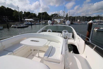 2004 Princess 61 luxury yacht in harbor with white interior.