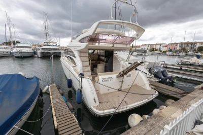Luxury 2013 Princess 42 yacht docked in a marina under cloudy skies.