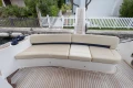 Curved beige seating on 2013 Princess 42 yacht deck, with wooden flooring.