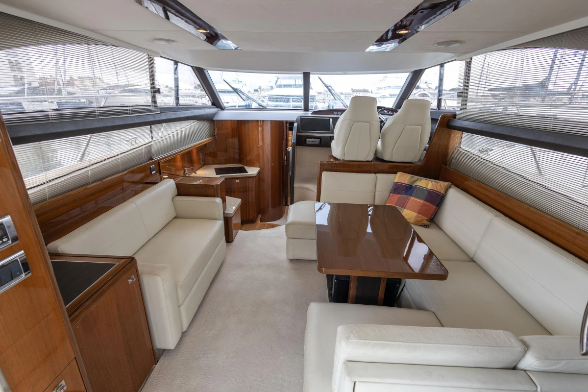 Luxurious interior of a 2013 Princess 42 yacht with elegant seating and wooden accents.