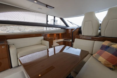Luxurious interior of 2013 Princess 42 yacht with elegant seating and wooden table.