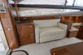 Luxurious interior of 2013 Princess 42 yacht with cream sofa and wooden cabinetry.