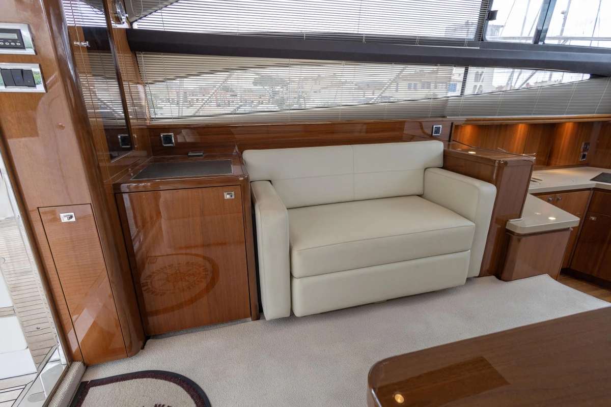 Luxurious interior of 2013 Princess 42 yacht with cream sofa and wooden cabinetry.