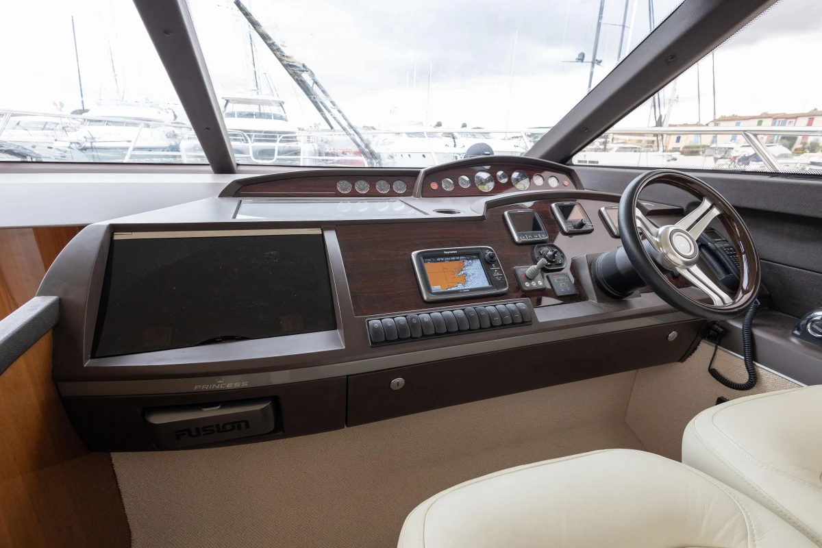 Helm of 2013 Princess 42 yacht with modern navigation equipment and steering wheel.