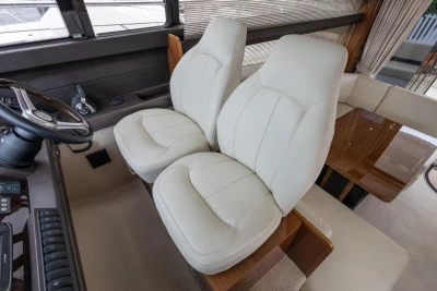 Luxurious interior seating of a 2013 Princess 42 yacht with plush white chairs.