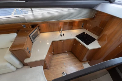 Luxurious kitchen interior of 2013 Princess 42 yacht with modern appliances and wooden cabinetry.