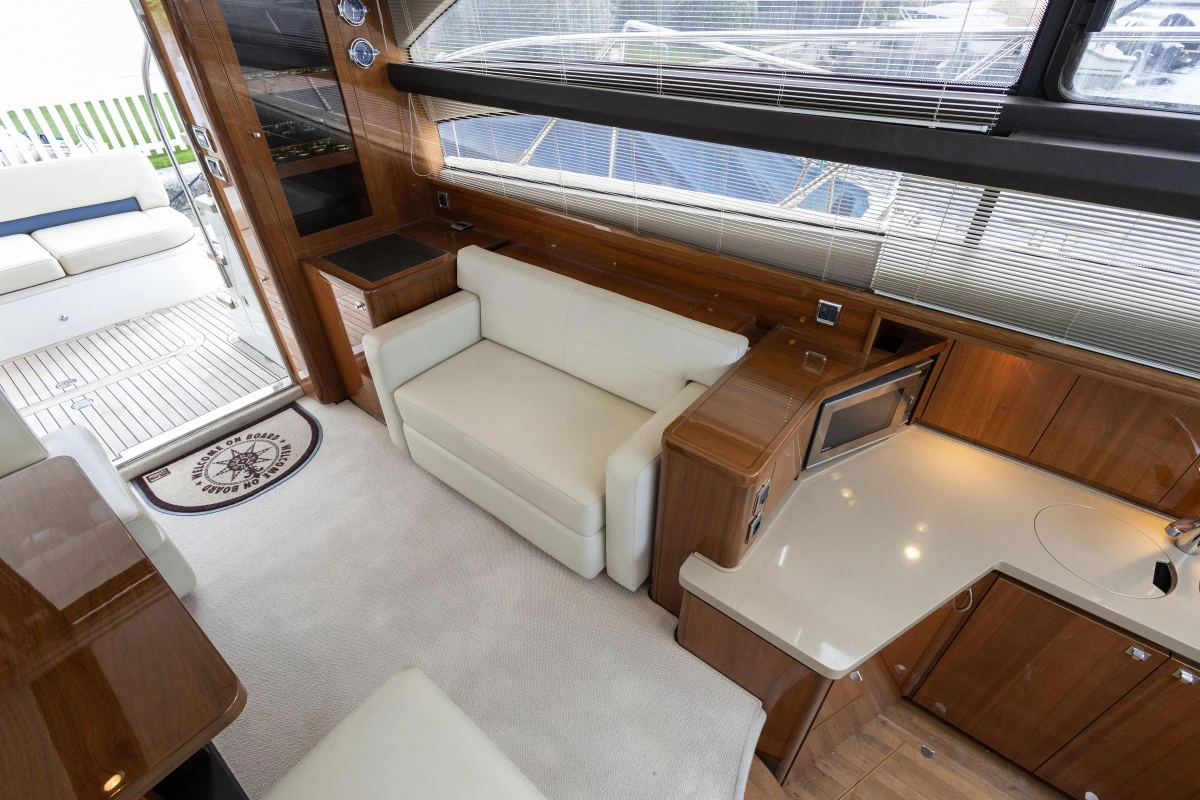 Luxurious interior of 2013 Princess 42 yacht with white seating and wooden cabinetry.