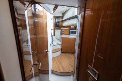 Luxurious interior of 2013 Princess 42 yacht, featuring wood finishes and modern kitchen amenities.