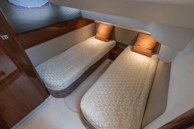 Twin cabin with beige bedding in a 2013 Princess 42 yacht.