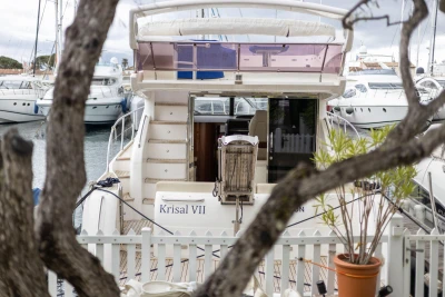 A 2013 Princess 42 yacht docked at a marina, surrounded by other boats.