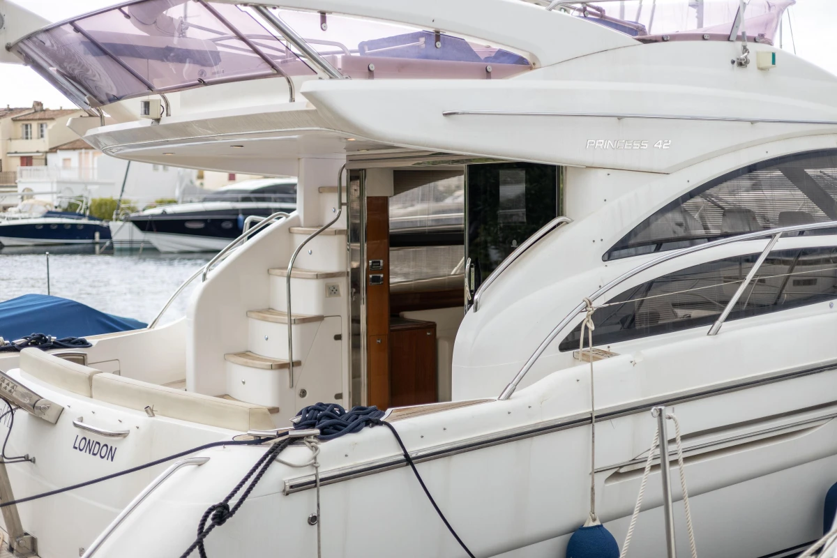 Luxury Princess 42 yacht, 2013 model, docked at marina with elegant design and spacious deck.