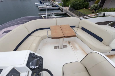 Luxurious seating area on a 2013 Princess 42 yacht with a wooden table.