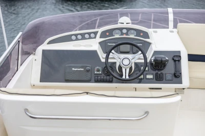 Control panel of a 2013 Princess 42 yacht with steering wheel and navigation instruments.